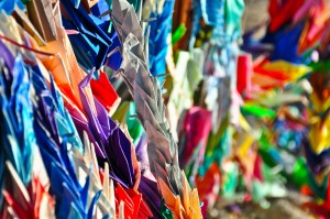 A nest of paper cranes rests on a desert gravestone in Manzanar cemetery.  They are left by visitors to commemorate the dead. Photo by Ryan Kuramitsu