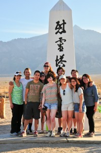 The group poses with Munteanu (left) in front of a monument in Manzanar cemetery. Photo by Ryan Kuramitsu